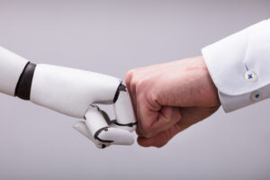 KCS and AI: Robot And Human Hand Making Fist Bump On Grey Background